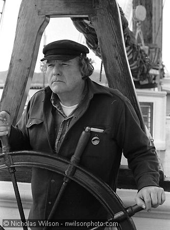 Byrd Baker poses at the helm of the C.A. Thayer, an old-time lumber schooner on display at the Maritime Museum, Hyde St. Pier, San Francisco CA