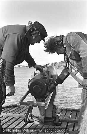 Byrd Baker, left, examines a whaling harpoon cannon on the Sioux City, a former whalling ship moored at Richmond CA.