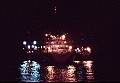 A large Russian mother ship takes on frozen fish and provides supplies to two of at least a dozen 300 ft. Soviet trawlers operating just outside the 12-mile limit off the California Coast on the night of July 3, 1976. In this end view a trawler can be seen on each side of the mother ship.