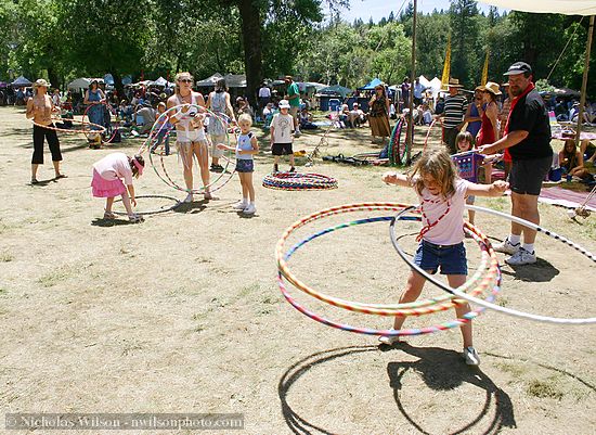 A girl spins four hula hoops