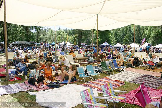 Some of the audience enjoys the shade of a canopy at the Kate Wolf festival 2005