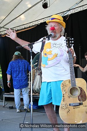 Wavy Gravy shows the guitar signed by many players which was raffled as a benefit for Seva Foundation's work against blindness