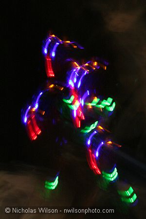 A dancer with flashing lights in a time exposure