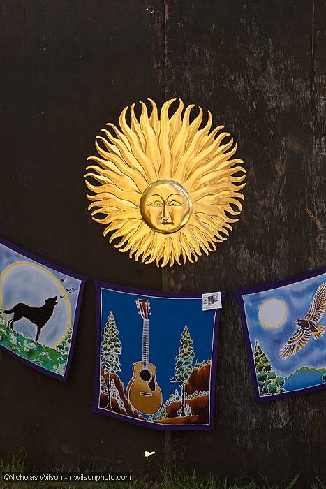A metal sunburst and Kate Wolf themed batik art adorn the entrance to the backstage dining area.