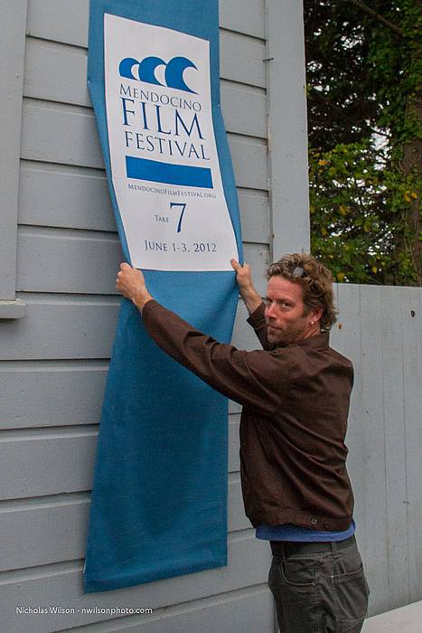 It's a wrap! MFF production volunteer Joe Chisholm strikes a poster and banner from Crown Hall. Joe was in the cast and crew of the Academy Award winning documentary "The Cove."