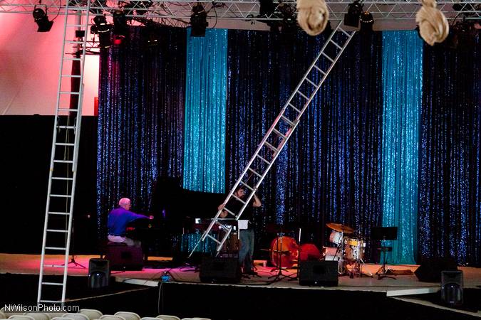Assisstant Technical Director Nick Tringale sets a big ladder to reach the stage lights as Ted Kidwell continues tuning the piano.