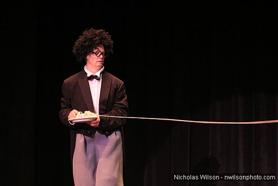 Bill Irwin stretches a long, long piece of spaghetti in performance at Cotton Auditorium, Fort Bragg CA